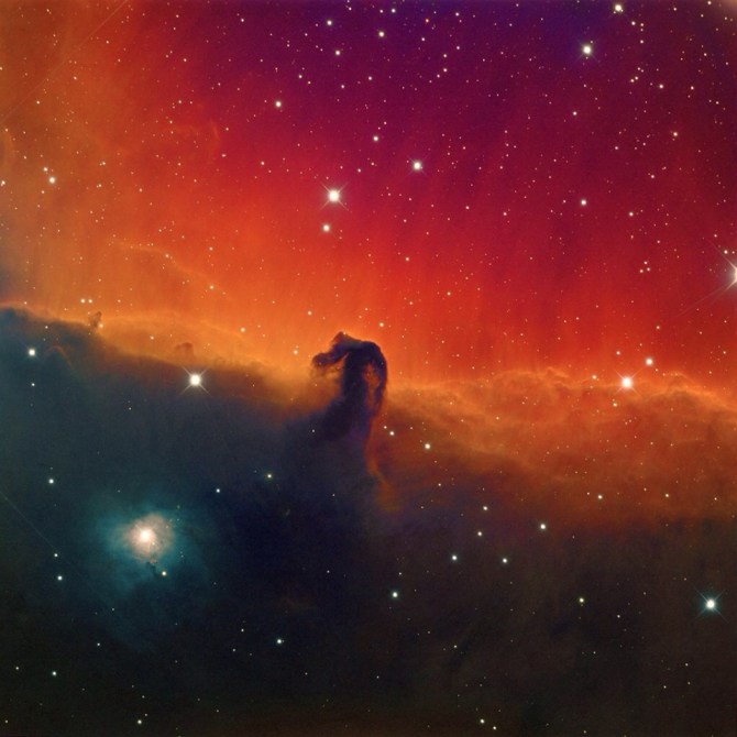 This is the Horsehead Nebula: "The red or pinkish glow originates from hydrogen gas predominantly behind the nebula, ionized by the nearby bright star Sigma Orionis."